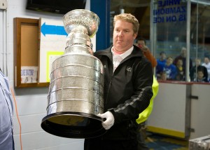 Mike Bolt, official ''cup keeper'' from the Hockey Hall of Fame carries the Stanley Cup into Loring Arena, Framingham, MA (October 15, 2011)
