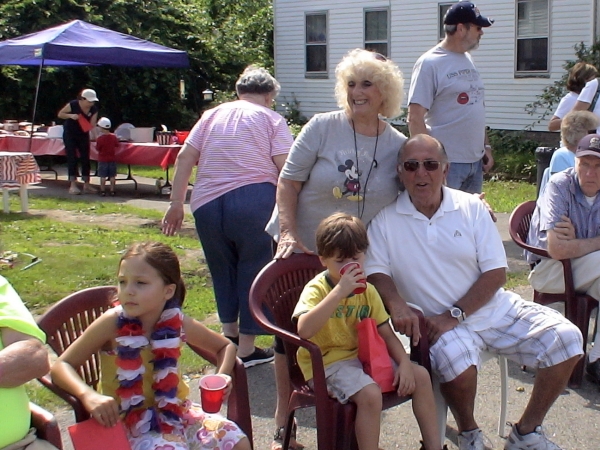 Framingham residents Roz Harris, Sara, Jacob and Lou Fritz watch the parade from a Natick friend's front lawn.